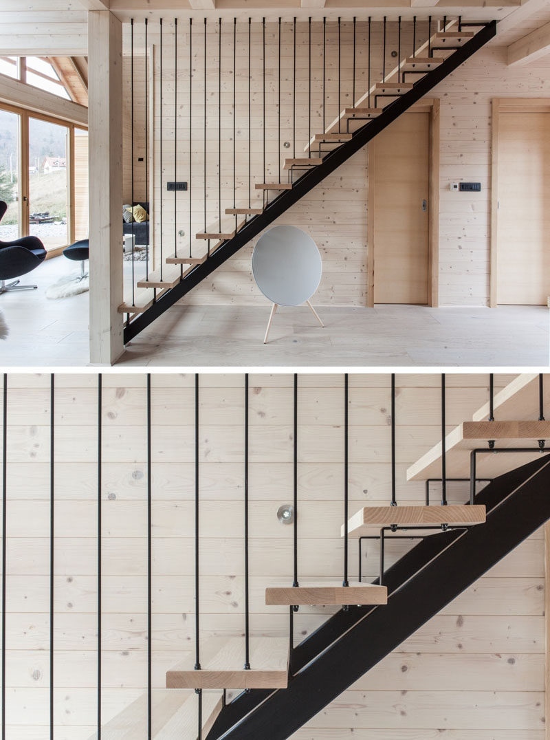 Black steel and light wood stairs lead to the upper floor of this modern house.