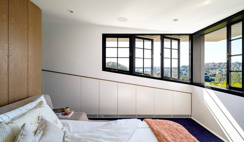  This master bedroom features black framed windows that can be opened, while deep eaves provide protection from the sun.