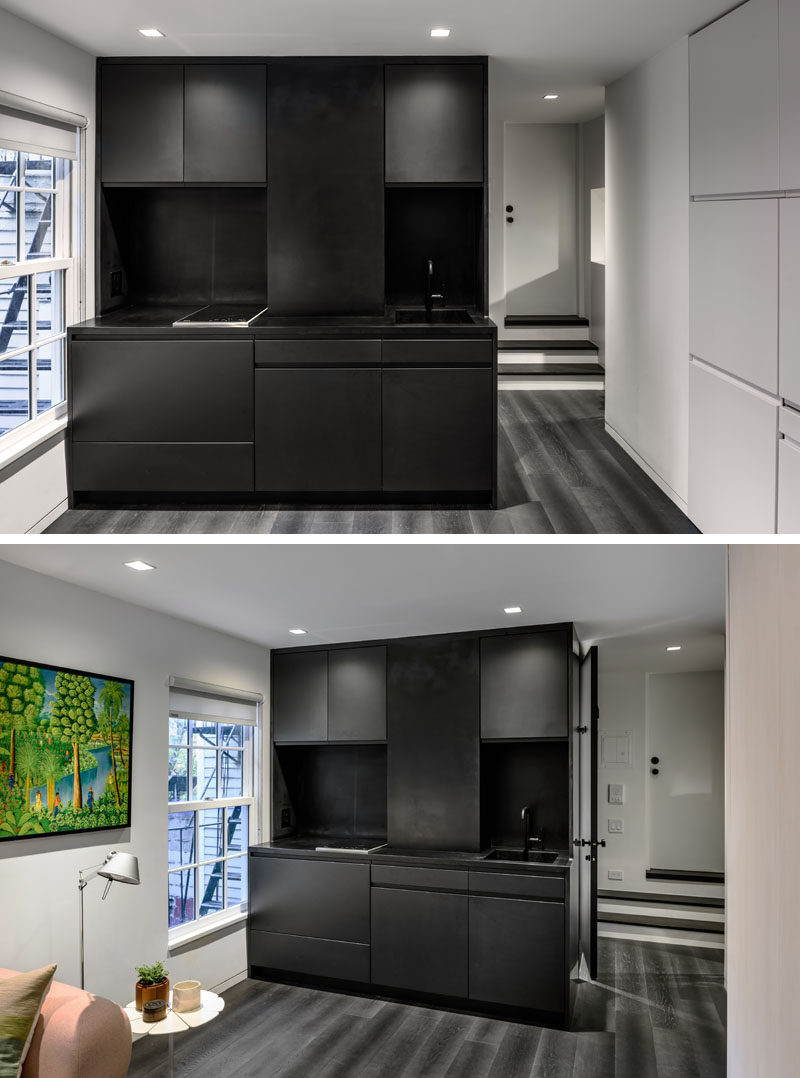 The black kitchen is the only dark space in this micro apartment and it has a compact design, with a small sink and a tiny cooktop. The designers have maximized the amount of cabinet space by having them go all the way to the ceiling.