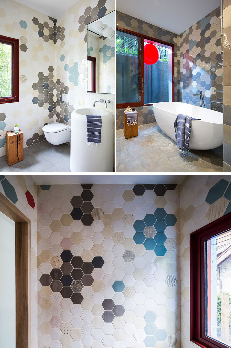 In this modern bathroom, hexagon tiles in a variety of colors ranging from light to dark, cover the walls from the floor right up to the ceiling.