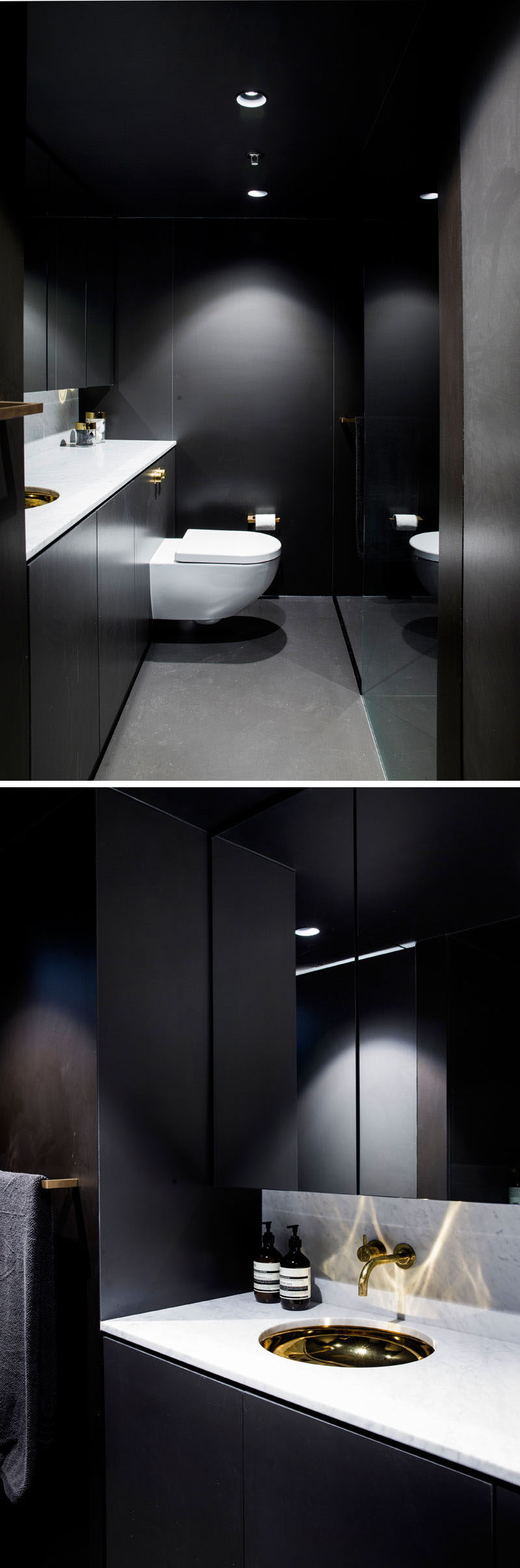 This dramatic black bathroom features a floor-to-ceiling mirror, grey flooring, a white countertop and gold accents.