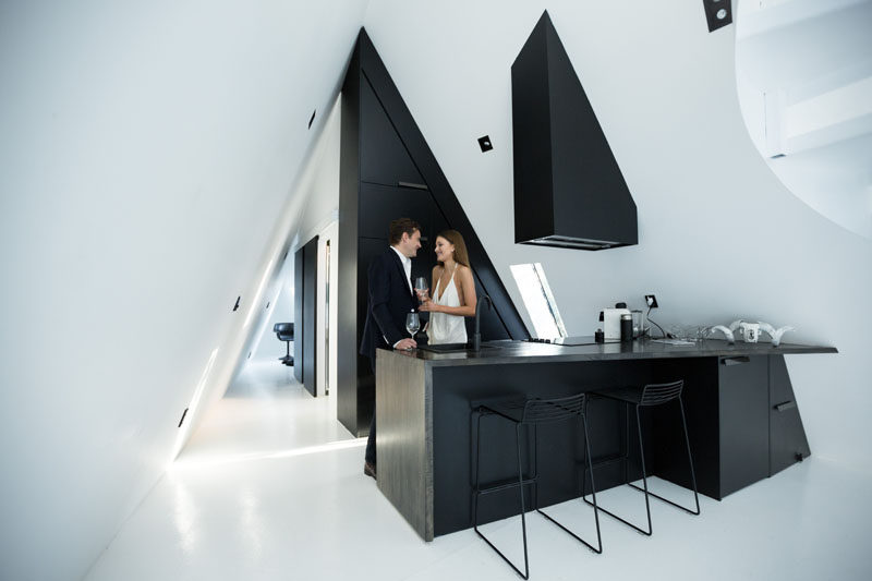 The modern matte black kitchen has been designed to perfectly fit the triangular shape of the interior, with the angles accentuated by the strong contrasting lines of the cabinetry.