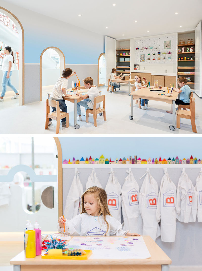 In this modern playroom, a soft blue ombre wall almost looks like the sky, while a peg board wall and cabinets are home to craft items.
