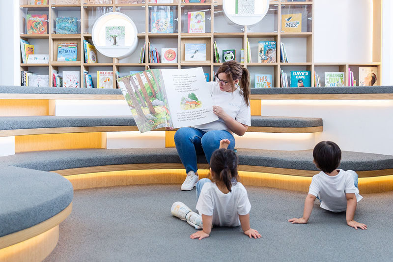 In this modern library, children can sit and read by themselves, or with an adult. Tiered seating with upholstered cushions and hidden lighting creates an ideal space for storytelling.