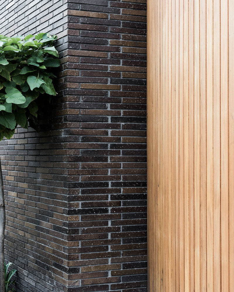 This modern house features horizontal dark brick and light wood throughout.