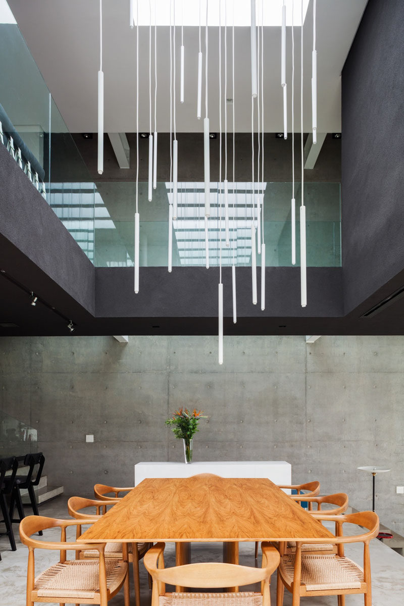 This modern dining area is positioned to take full advantage of the void in the ceiling and the skylight above, with the artistic light installation drawing your eye upwards to the open space.