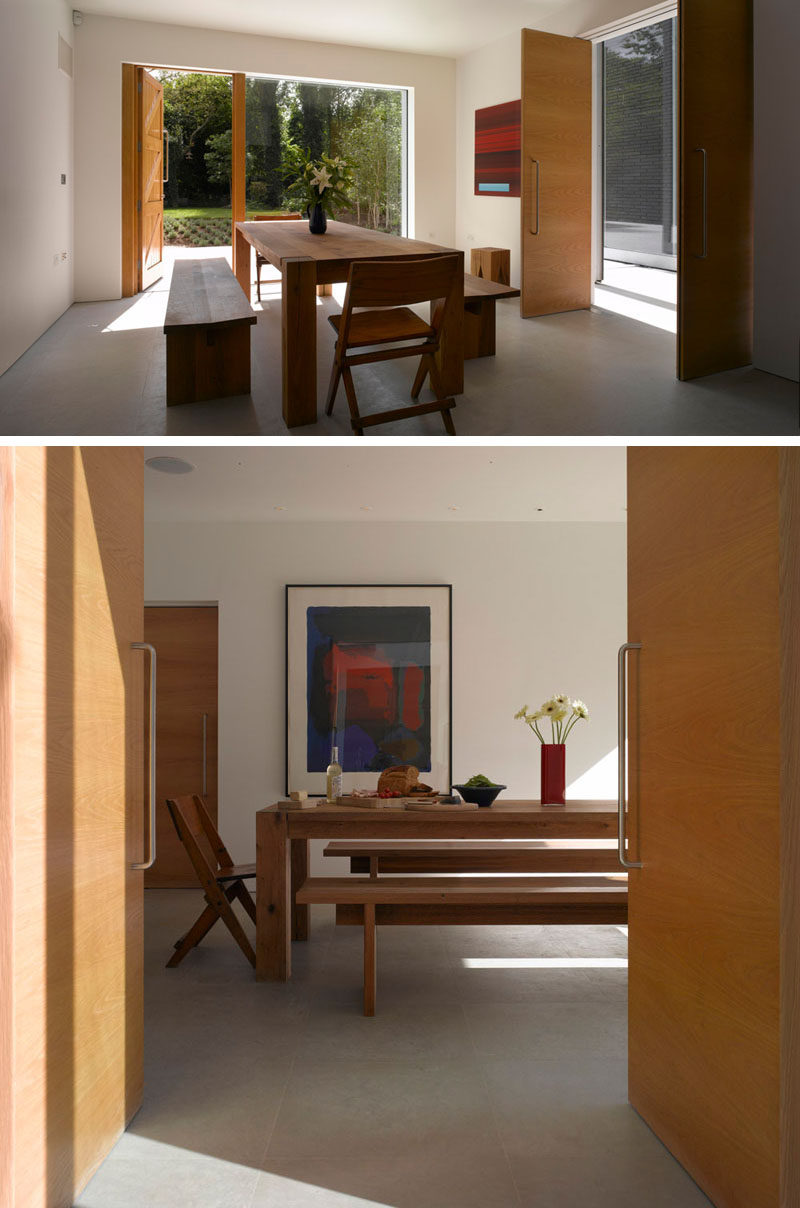 This dining room has a simple, rustic modern feel to it with a large wood table and bench seating. 