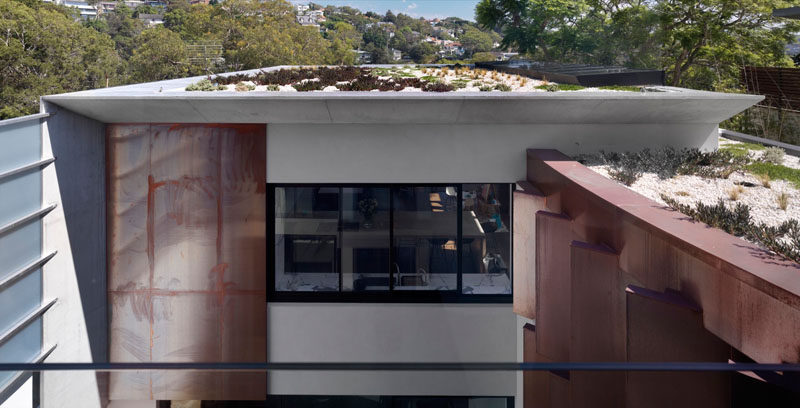 This modern house has a green roof to help with insulating the roof.