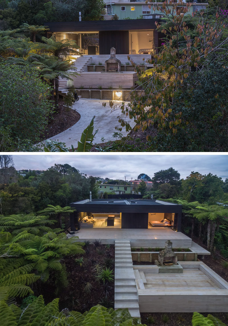 This modern holiday house in New Zealand has a black wood exterior and an outdoor entertaining area.