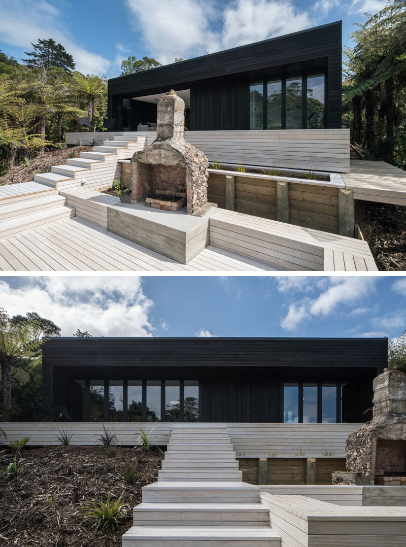 Simplicity and symmetry was key in the design of this modern holiday house, while dark cedar cladding covers the exterior, light wood stairs lead up to the home. Off to the side of the stairs is an outdoor entertaining area with a fireplace and built-in bench seating.