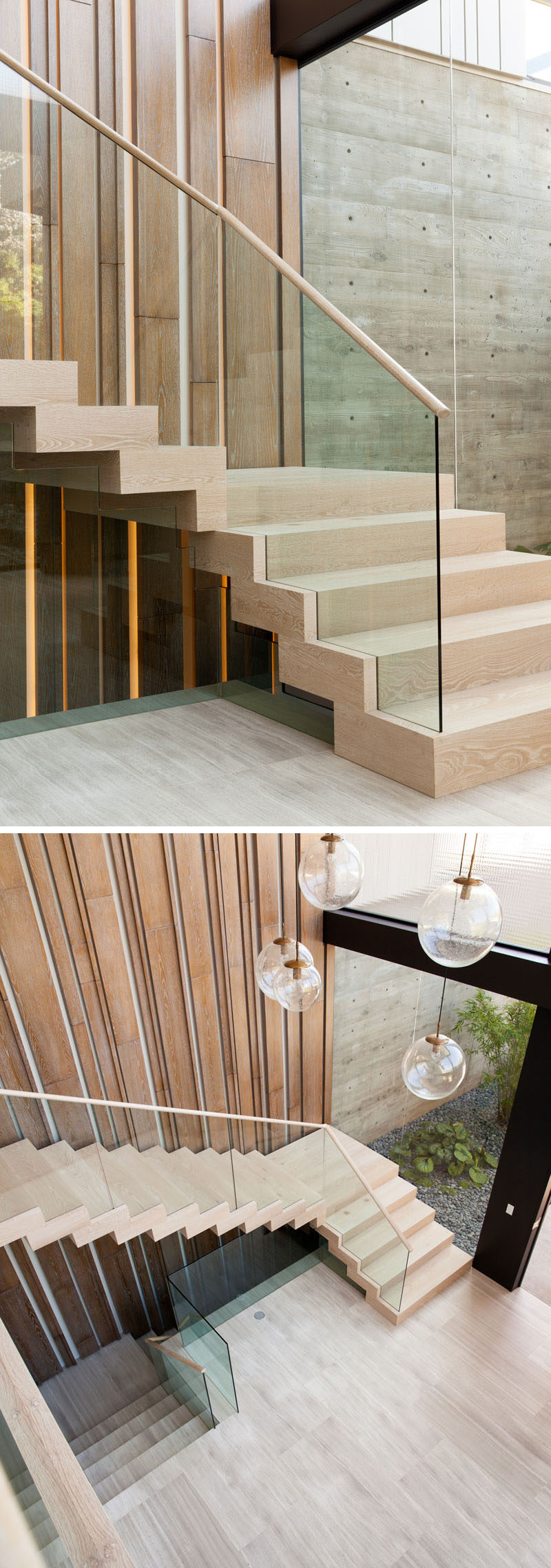 In this modern house, light wood stairs lead up to the second floor of the home., and a vertical wood accent wall with hidden lighting helps to emphasize the height of the foyer.