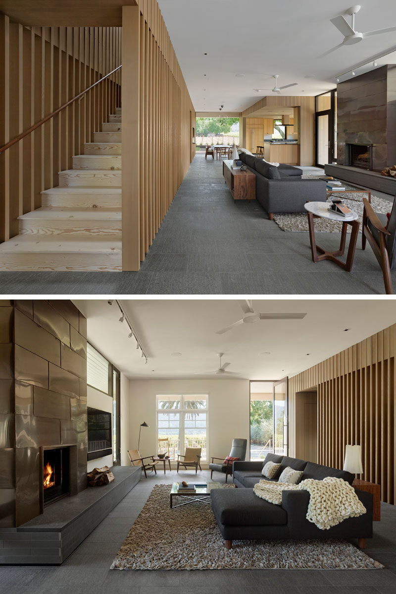 This modern living room has the couch is focused on the fireplace and its copper surround.