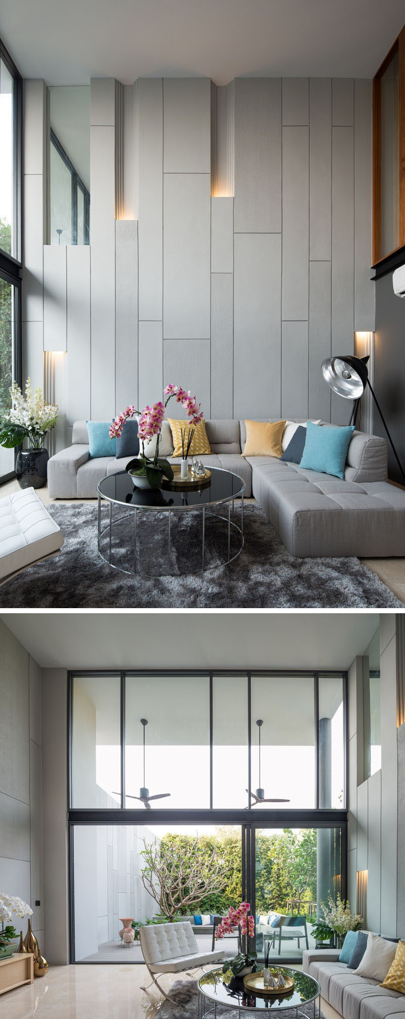 In this modern living room, the double-height space has large windows that look out onto the backyard. The wall behind the couch has built-in lighting to break up the solid wall, as well as helping to creating a unique atmosphere.