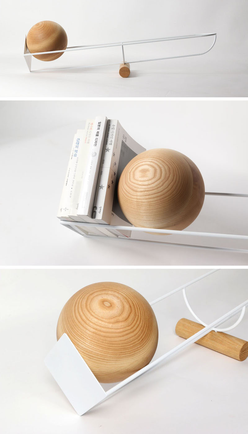 This simple and unique bookshelf is designed like a see-saw, with a wooden ball that rolls depending on where the weight on the shelf is.