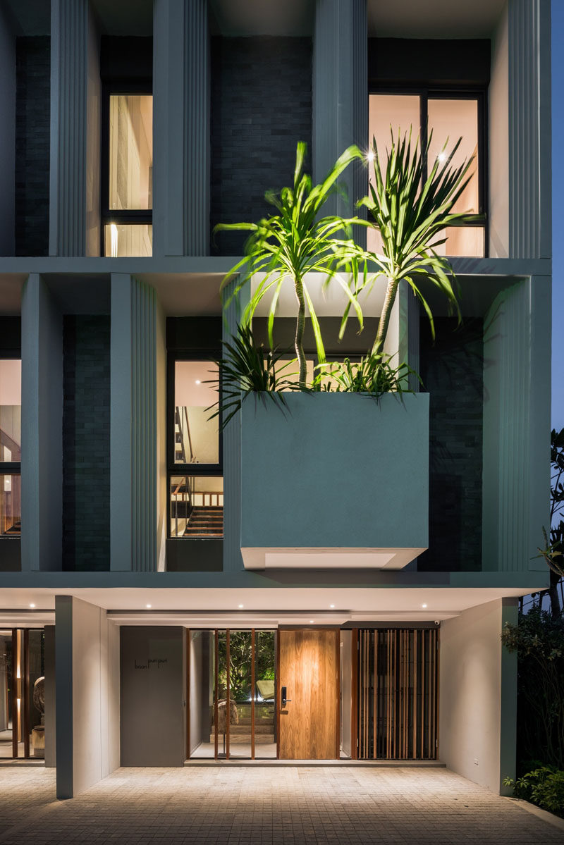 This modern townhouse has a large cantilevered planter box that stands out and add a touch of nature to the facade.