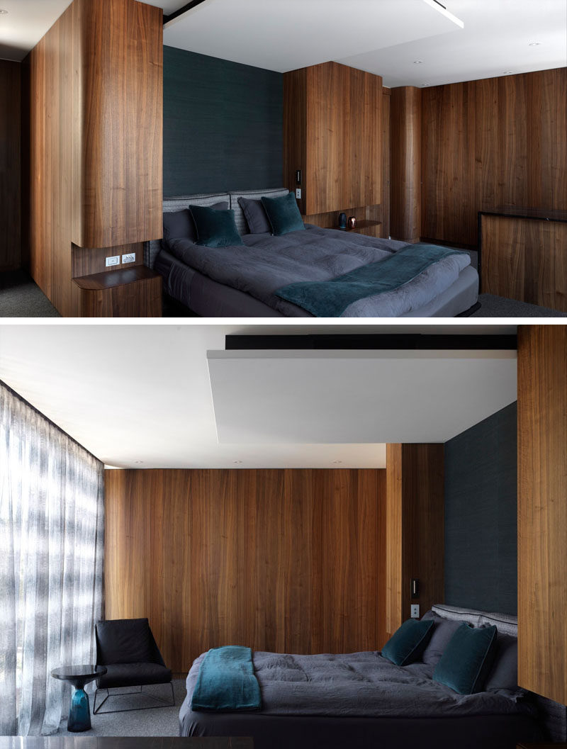 This modern bedroom features rich wood walls and built-in bedside tables, and when combined with grey bedding gives off a luxurious feeling.