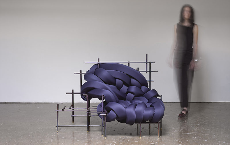 American designer Evan Fay, has created the Lawless Chair, a sculptural oversized seat made from steel rods and woven strips of dark blue upholstered cushions.
