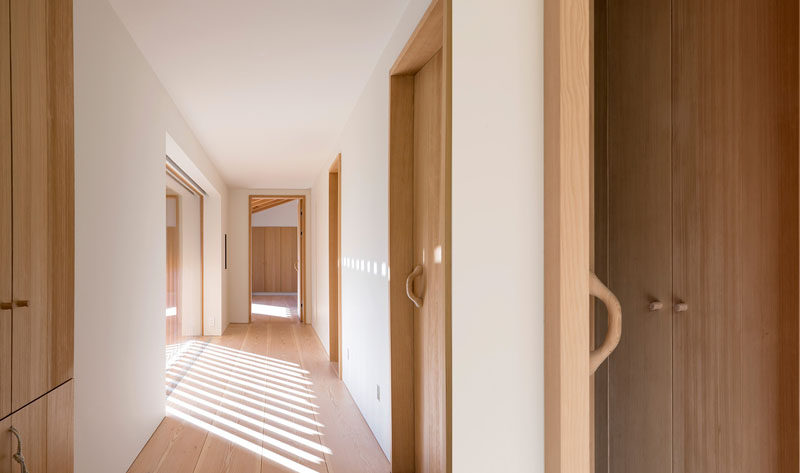 White plaster covers the walls in this hallway, and when paired with light wood doors and flooring, creates a contemporary interior.