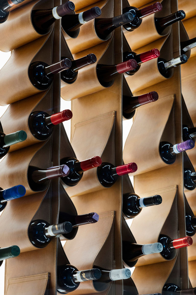 This renovated restaurant in Toronto, features a unique custom designed wine display made from leather that cradles the bottles of wine. It is also back lit and framed behind a glass wall, making it more like a piece of artwork than a storage solution.