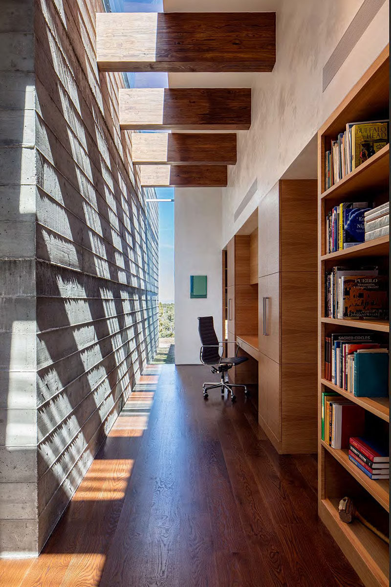 There's a home office in this hallway, with a built-in wood bookshelf and a desk.