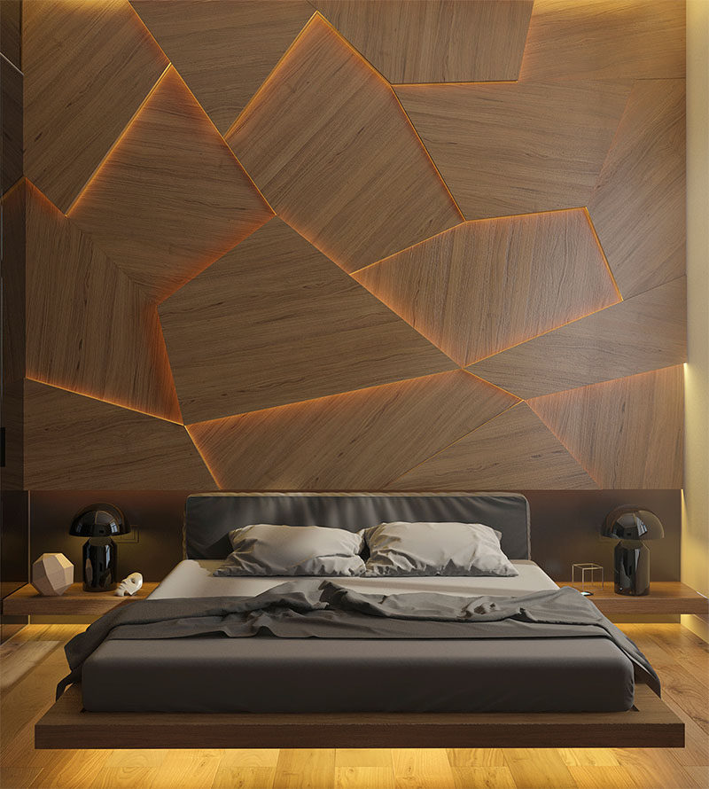 A bedroom accent wall made from geometric wood panels and hidden LED lighting.