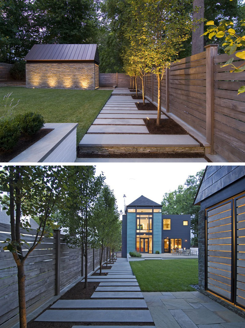  A concrete, paved modern walkway runs along the side of the yard, leading from the front to the back of the yard.