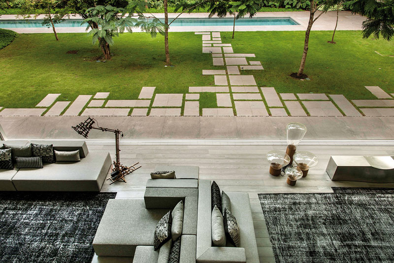 Square concrete pavers are arranged geometrically in the backyard of this modern home creates a distinctive walkway.