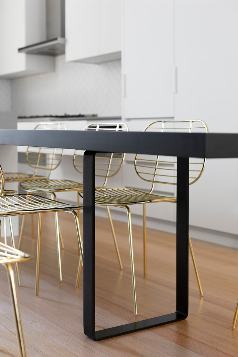 Surrounding this modern black kitchen table is a set of gold chairs adds a touch of glam to the space and makes it feel more sophisticated.