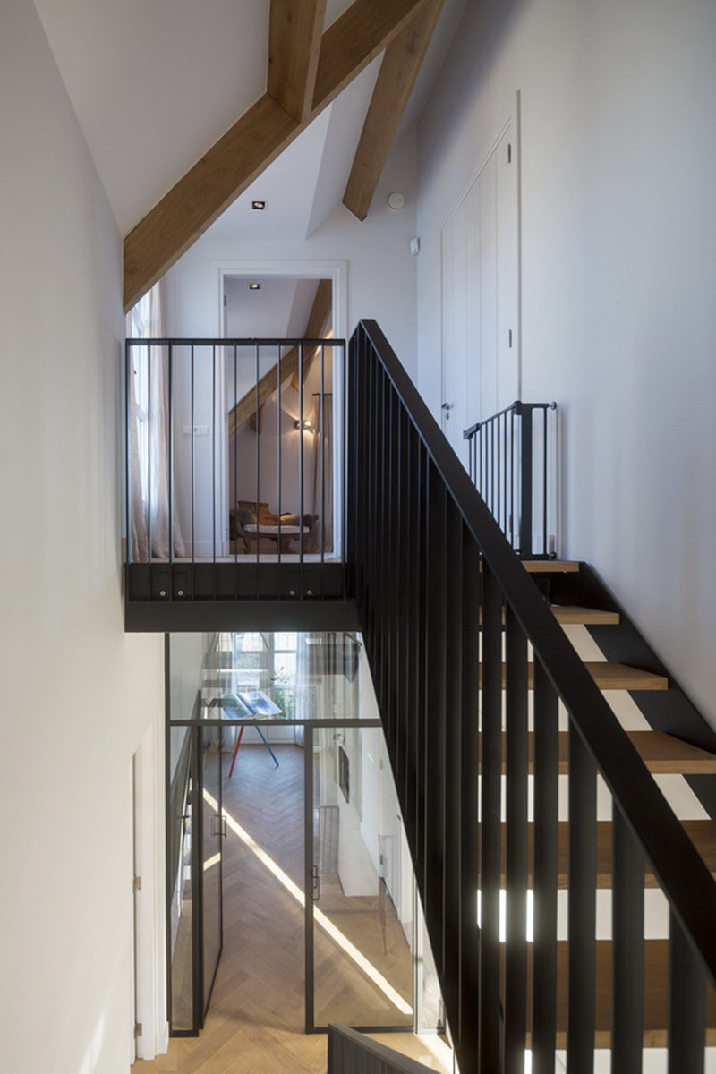 Wood and black steel stairs lead up to the top floor of this modern home.