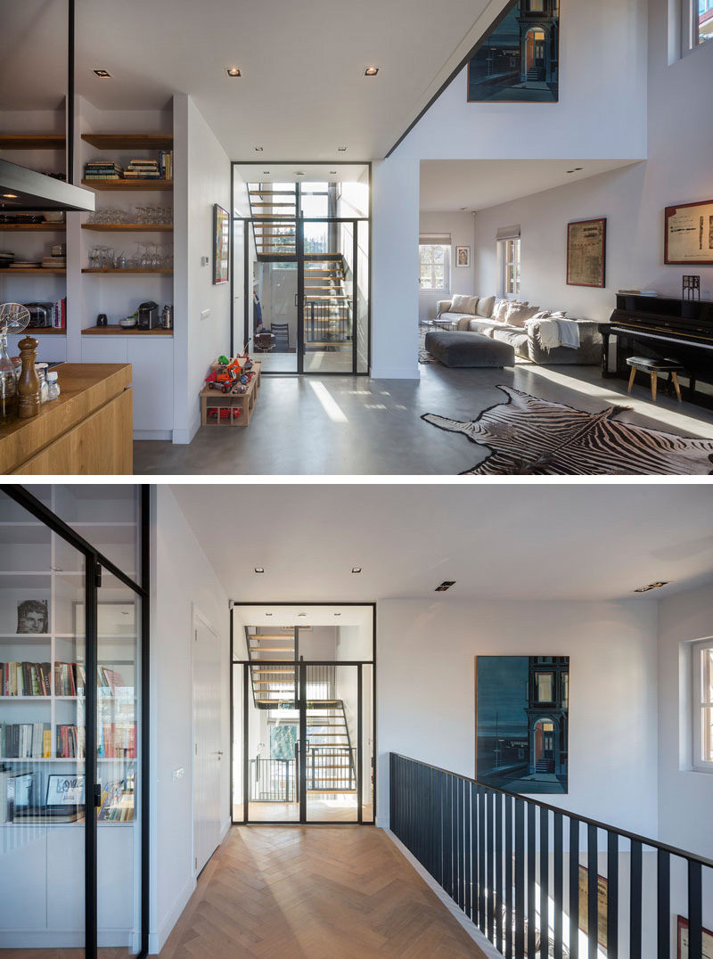 Located of the living room in this modern home are stairs that lead to the upper floor of the home. Light wood flooring laid in a herringbone pattern is used to contrast the black railing on the balcony, which matches the black frame work found throughout the home.