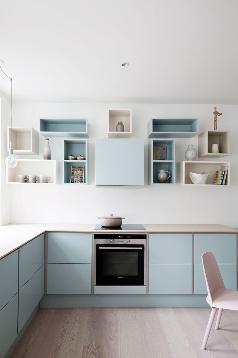 A soft blue has been used on the lower cabinets, as well as on and inside of some of the upper open box shelves to create a bright, welcoming kitchen.