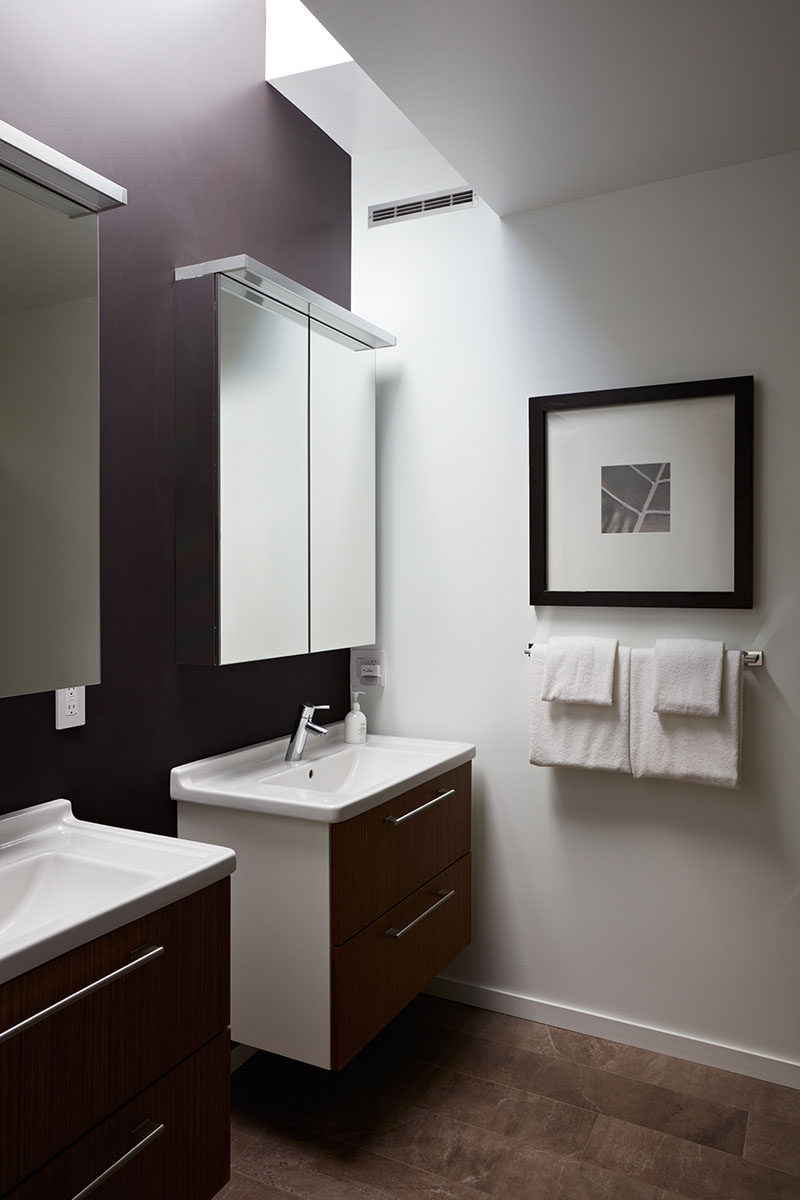 This contemporary master bathroom has 'his and her' sinks and a skylight adds a touch of natural light to the space.