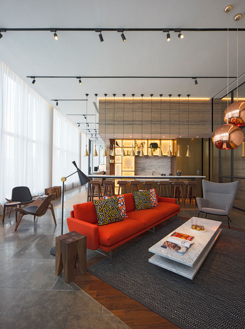 In this modern clubhouse there's a variety of different areas that residents can relax in, like this bar with a bright red couch.