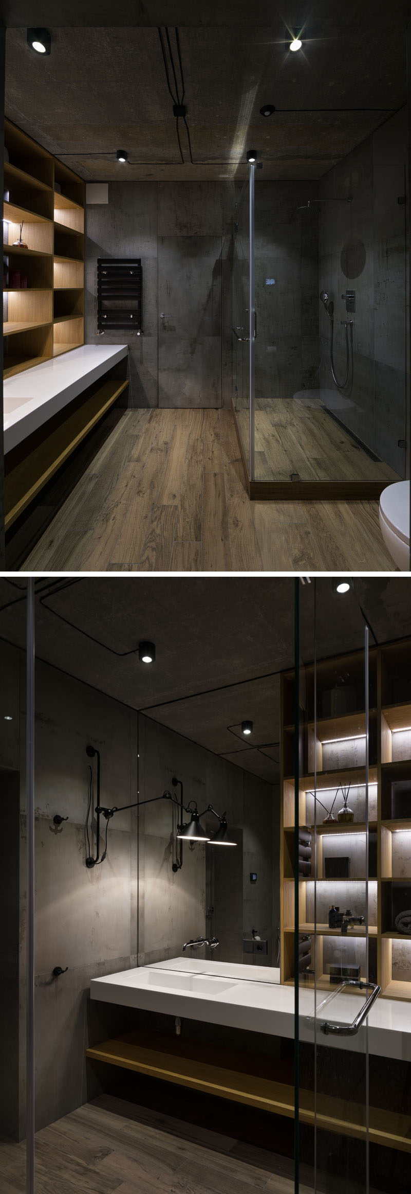 Wood flooring and concrete walls add an industrial touch to this bathroom, while the glass shower surround allows light to pass through. A section of the wall is made up of wood shelves with hidden lighting.