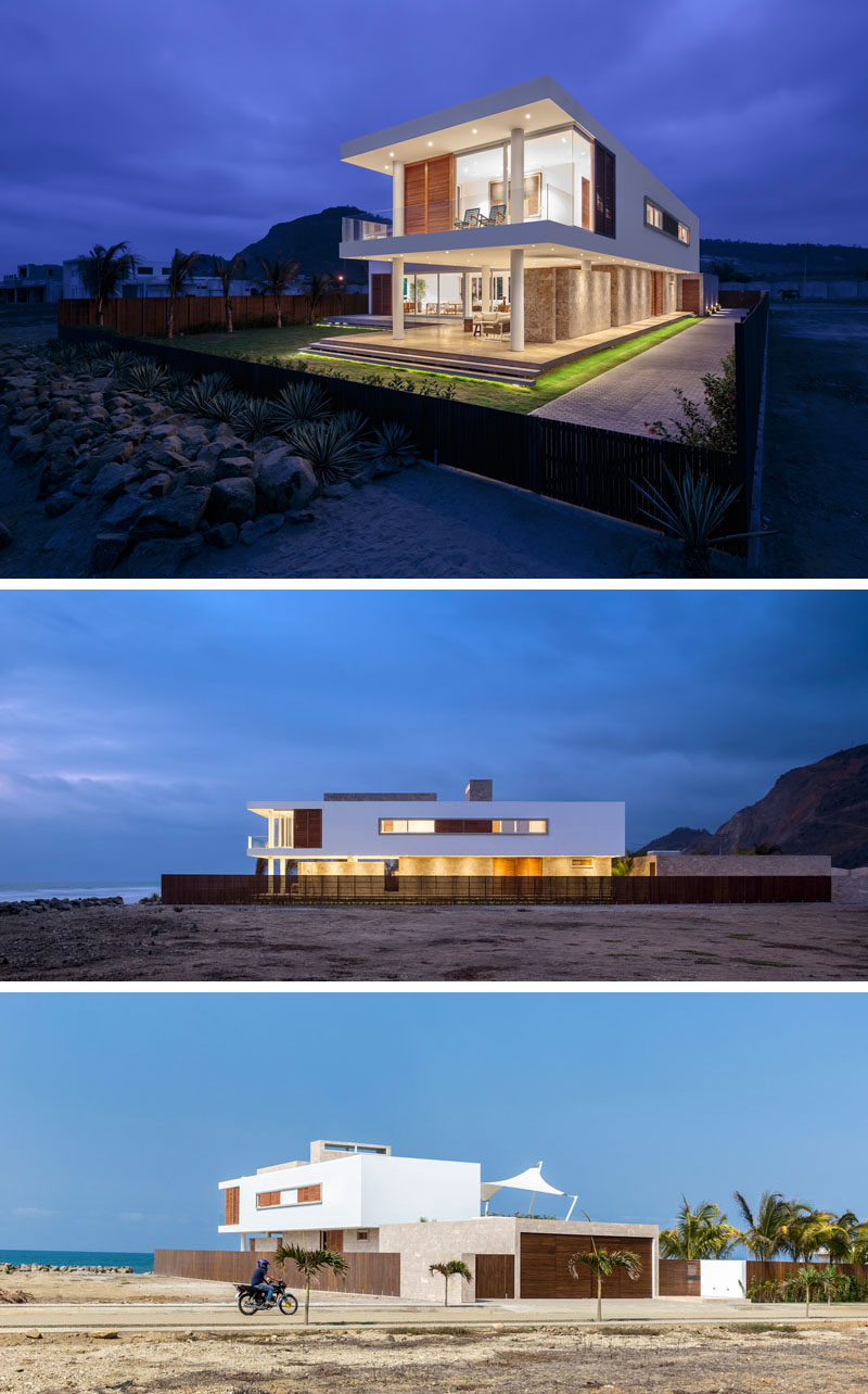 The exterior of this modern beach house naturally suits the landscape around it and has a material palette of white, wood, and stone. At night the residence lights up from all angles creating an ethereal effect.