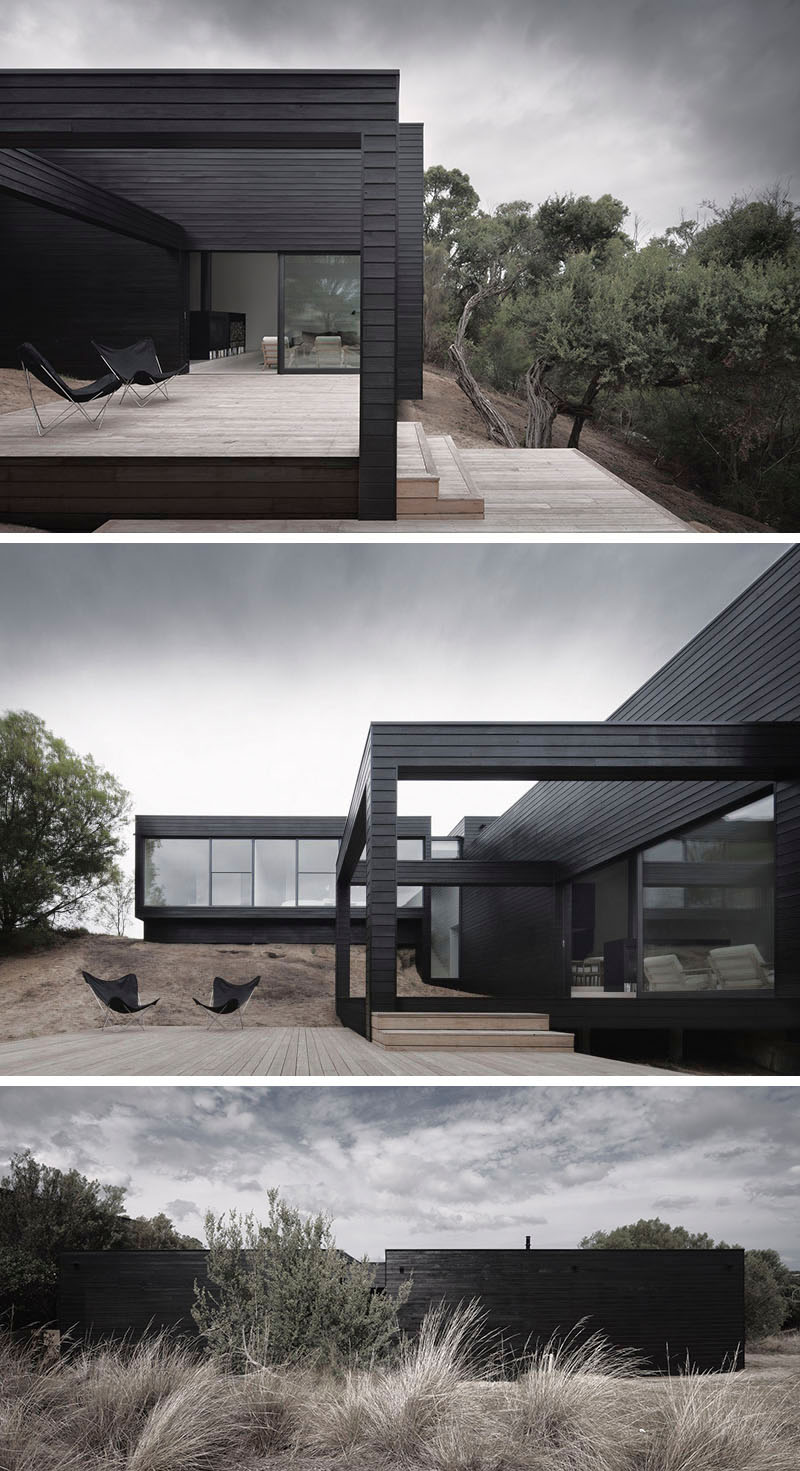 Large windows are the only things interrupting the all black siding on the exterior of this modern home. #ModernBlackHouse #BlackHouse #BlackExterior #BlackArchitecture