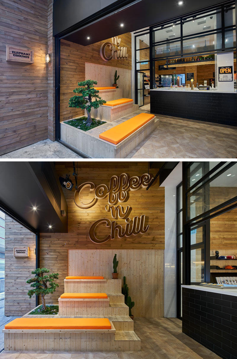 This modern coffee shop has custom designed wood tiered seating with orange cushions that sits below a lighted three dimensional wood sign that reads, "Coffee 'n Chill." A green bonsai and a few cacti add a touch of nature color to the seating arrangement in this indoor-outdoor anteroom. 