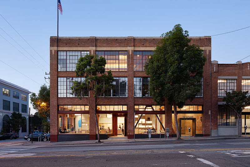 The brick building that houses this modern cafe is a former Kohler warehouse that has been transformed into a bright and inviting space. The large red framed windows that line the front of the building blend in with the exterior and reveal the warm interior of the cafe.