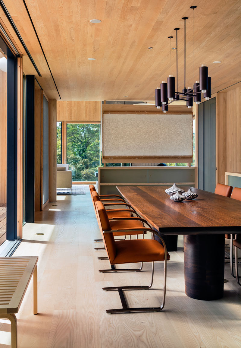 Upon entering this contemporary home, you walk into the main living and dining room. In the dining room, a large hand-carved wood table with a minimalist chandelier has plenty of room for family and guests.