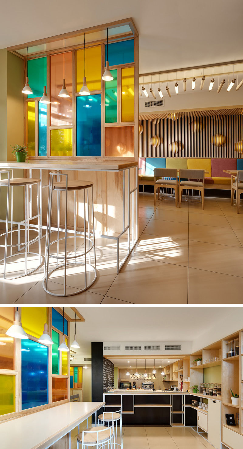 The colored glass paneled wall in this cafe-bakery creates a unique feature that matches the rest of the decor.