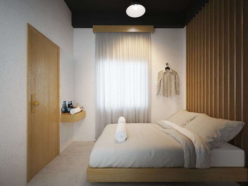 This private room in a modern hostel in Bangkok, has a wood slat accent wall that matches the wood door and bed frame.