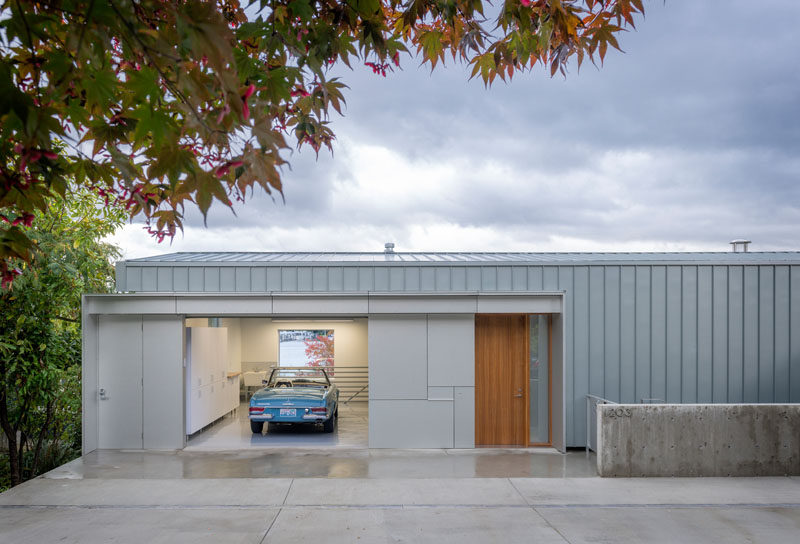 The exterior of this modern waterfront house has a shell of zinc and aluminum, with the garage and the wood front door being the only part of the house that you can see from the street.