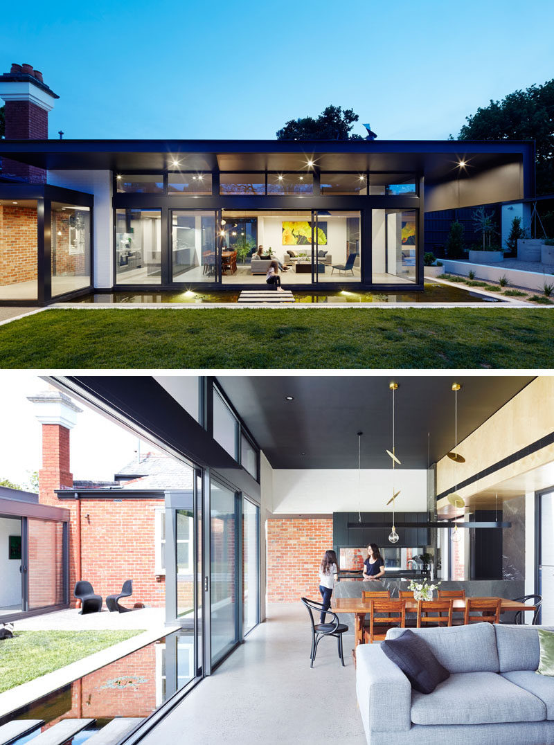 This modern house extension has a living room, dining area and a kitchen. You can see how the back brick wall of the original home is still visible in the new extension.