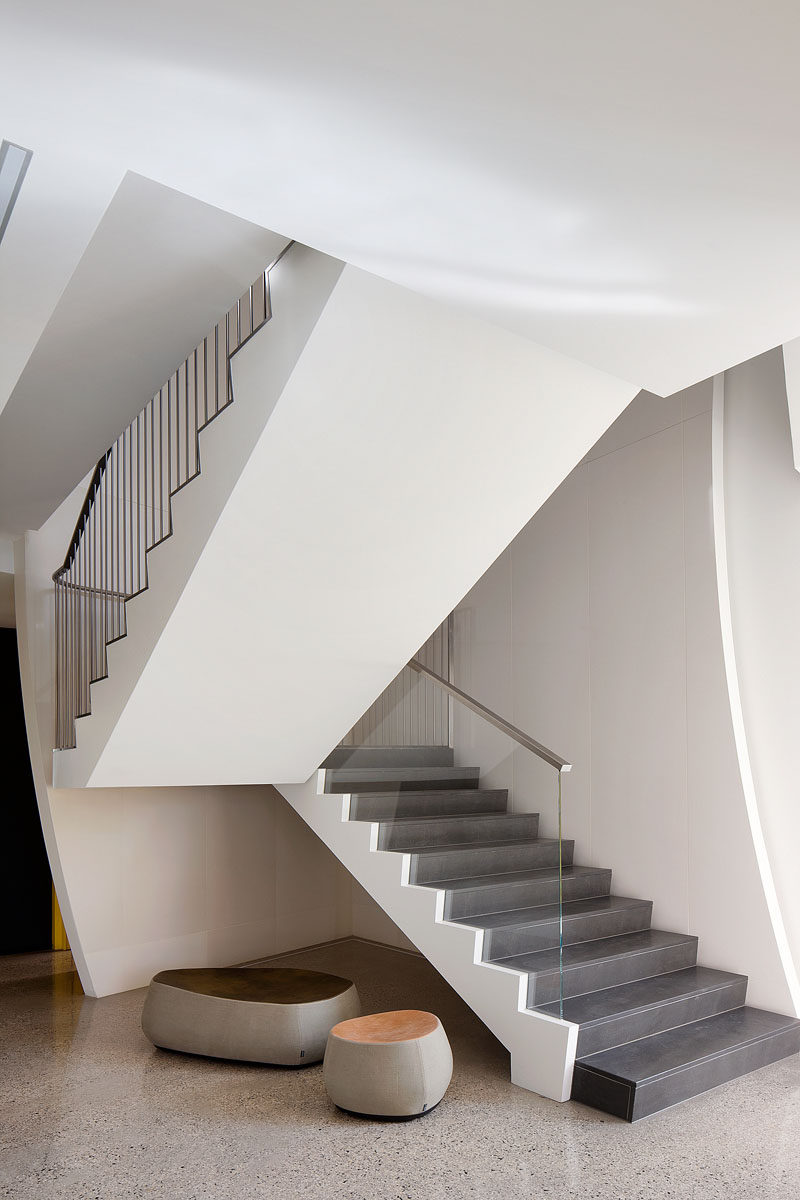 This modern staircase uses solid slab honed bluestone for the stair treads and rises.