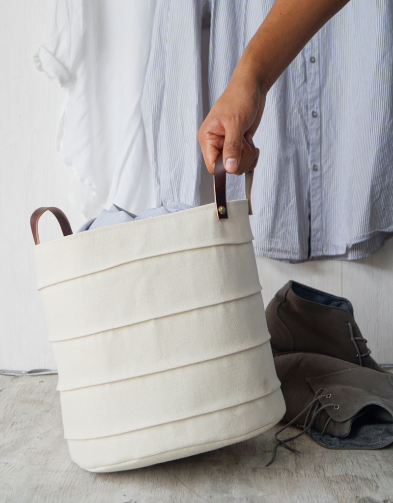 Delicate and light in an off-white color, this laundry basket has French seam detailing and brown leather handles. The exterior of the basket is made from 100% cotton canvas, with the lining made from 100% organic cotton.