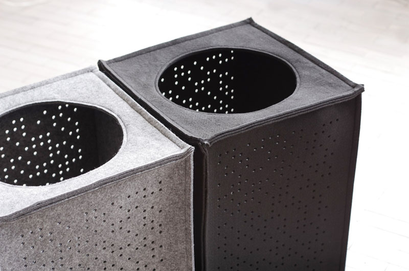 Made from polyester felt, these grey laundry hampers have cut out circular patterns. 