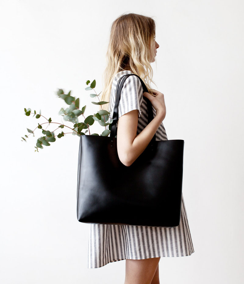 This large modern black tote has natural suede leather interiors.