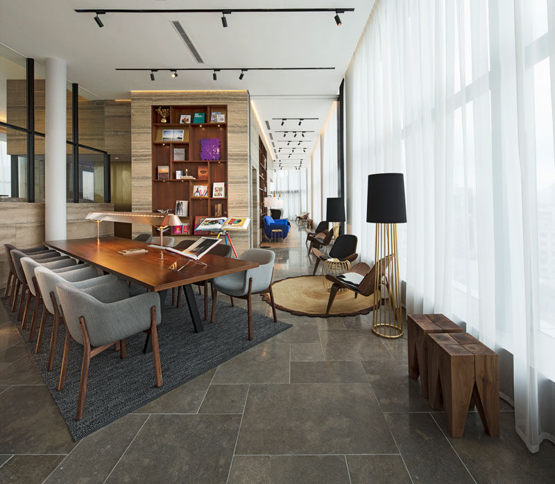 This modern residential clubhouse has a library with a work table and reading chairs.