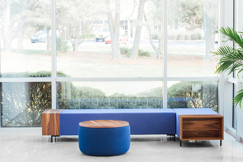 Designer Trevor Hoiland has created The Story Collection, a modern and modular office furniture series that's made with a wood storage cubby at the end of the seats, coffee tables and benches.