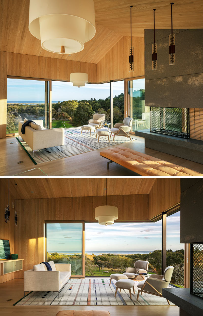 In this living room, large sliding glass windows meet at the corner and can be opened to enjoy an afternoon breeze, and on a cool night, a fireplace can be lit to add warmth.